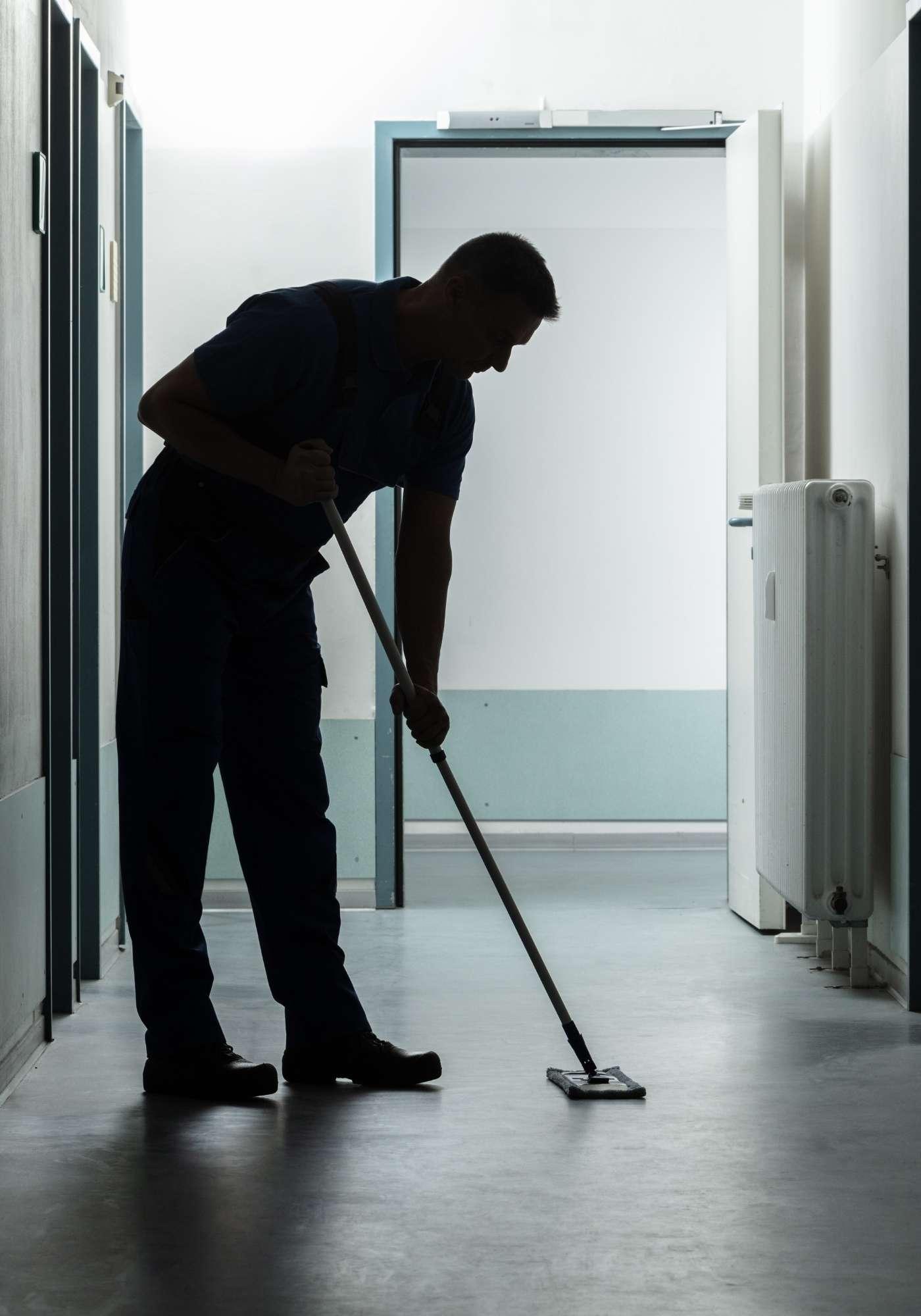a janitor mops a hallway for altius janitorial